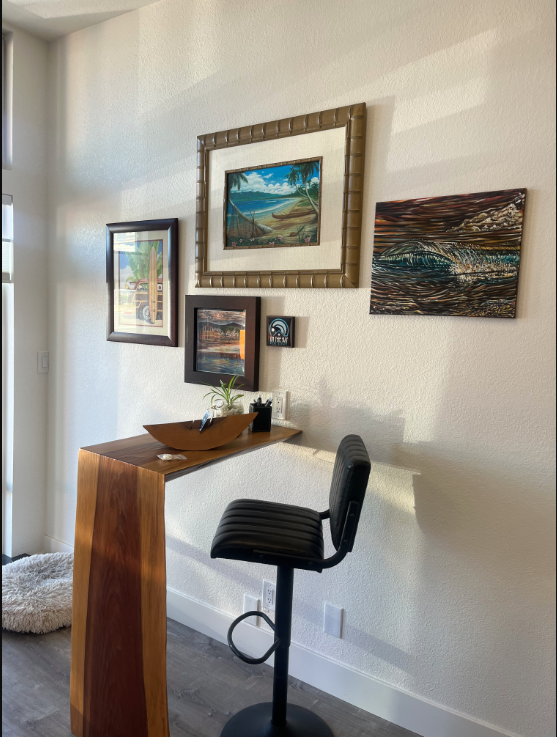 On The Bay office — styled corner with coastal art and live-edge desk